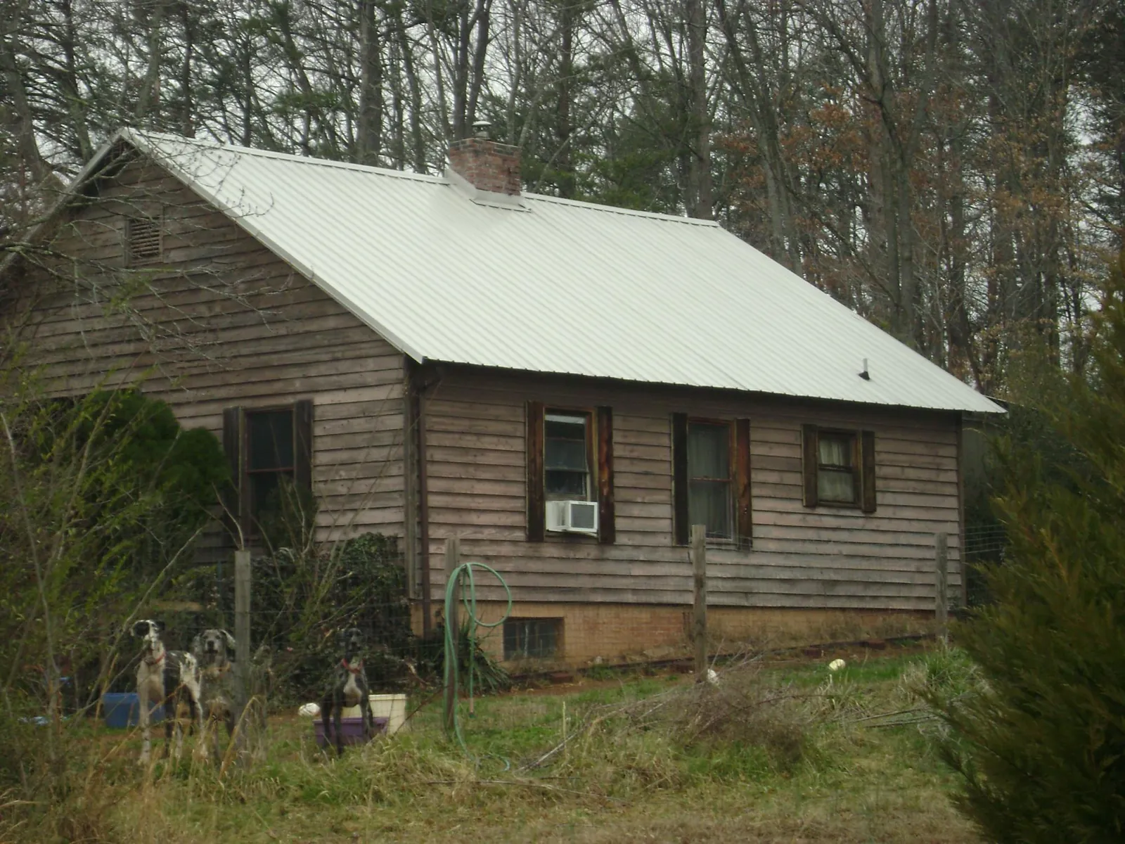 White metal roof on an old wood sided farmhouse, from a Metal Roof Installation job in Cedar Hill